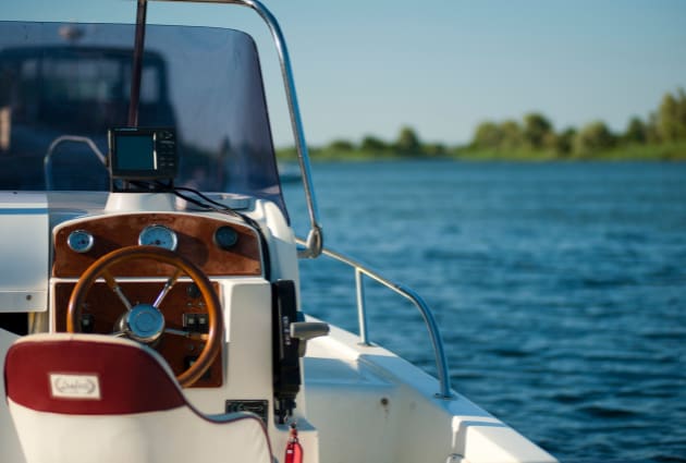 The helm of a motorboat on the water