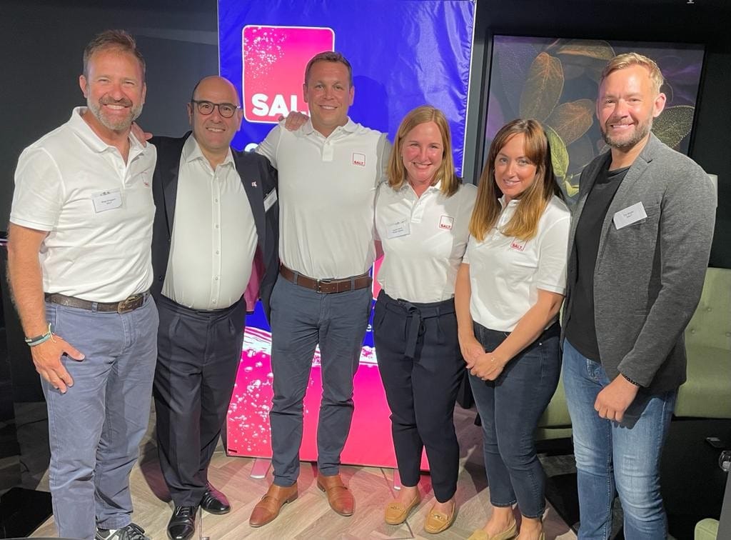 The SALT team together in front of a branded screen at the launch of the boat finance app